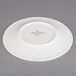 A Villeroy & Boch white porcelain plate with a white rim on a gray surface.