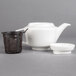 A white Villeroy & Boch porcelain teapot with a black plastic strainer basket.