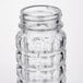 A close up of a clear Tablecraft glass shaker with a black and white lid.