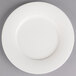 A Villeroy & Boch white porcelain plate with a small rim on a gray surface.