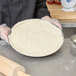 American Metalcraft Super Perforated Heavy Weight Aluminum Coupe Pizza Pan with pizza dough on a round pan.