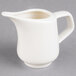 A white Villeroy & Boch porcelain creamer with a handle on a gray surface.