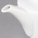 A close up of a white Villeroy & Boch porcelain teapot with a handle and filter.