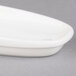 A white porcelain sugar bowl cover on a white dish.