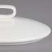 A white porcelain lid with a knob.
