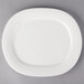 A white porcelain oval platter with a white rim.