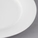 A close-up of a Villeroy & Boch white porcelain oval platter with a curved edge and a white rim.