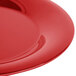 A close-up of a shiny red Carlisle Sierrus melamine plate with a wide rim.