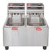 A Cecilware stainless steel electric countertop deep fryer with two fry tanks and two baskets.