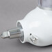A white KitchenAid mixer attachment with a silver handle.