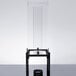 A clear glass Cal-Mil beverage dispenser with a black base and stand with a close-up of a faucet.