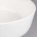 A close up of a Villeroy & Boch white porcelain salad bowl with a white rim.