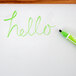 A green Expo 2-in-1 dry erase marker on a white board with the word hello written in green.