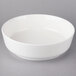 A white Villeroy & Boch porcelain salad bowl on a gray surface.