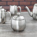 A mirror-finished stainless steel sugar bowl with a lid.