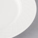 A close-up of a Villeroy & Boch white porcelain plate with a circular design.