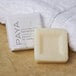 A PAYA Orange and Papaya facial bar of soap next to a white towel.