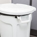 A white Rubbermaid BRUTE round trash can with black handles.