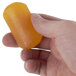 A hand holding a yellow PAYA Orange and Papaya bar soap.