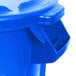 A blue Rubbermaid BRUTE round plastic trash can with a lid.