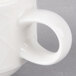 A close-up of a white porcelain Villeroy & Boch stackable cup with a handle.