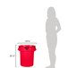 A woman standing next to a red Rubbermaid BRUTE trash can with a black lid.