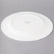 A white porcelain round platter with a circular design on it.