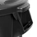 A close-up of a black Rubbermaid BRUTE trash can with a lid on it.