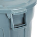 A close up of a gray Rubbermaid BRUTE round trash can with a lid.