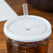 A Cambro translucent lid on a cup with a plastic straw.