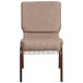 A beige Flash Furniture church chair with a copper vein metal frame and book rack.