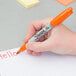 A person holding a Sharpie fine point marker with a hello note on it.