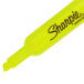 A close up of a Sharpie yellow highlighter with black writing on it.