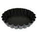 A black round Matfer Bourgeat fluted tartlet pan with wavy edges.