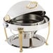 A Bon Chef stainless steel roll top chafer with gold accents on a table.