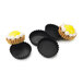 A group of black Matfer Bourgeat Exoglass tartlet molds filled with small tarts with yellow and white frosting.