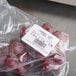 A plastic bag of red grapes with a label printed from a Tor Rey WiFi price computing scale.