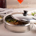 A stainless steel Town Dim Sum Steamer with a lid on a table of food.