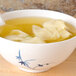 A Blue Bamboo melamine soup bowl filled with dumplings in soup.