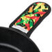 A Lodge multi-color chili pepper pattern handle holder on a pot handle.