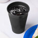 A black plastic cup filled with ice.