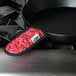 A red bandana with white text on a black pan handle.