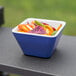 A Vollrath extra-small square melamine bowl with blue and white food inside.