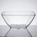 A clear acrylic square bowl on a table.