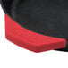 A red Lodge silicone handle holder on a black pan.