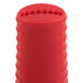 A red cylindrical silicone handle holder for Lodge pre-seasoned carbon steel skillets.