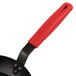 A red Lodge silicone handle holder on a black Lodge carbon steel skillet handle.