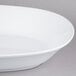 An American Metalcraft white oblong melamine serving bowl on a gray surface.