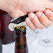 A person using a Pullparrot waiter's corkscrew to open a bottle of wine.