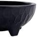 A black melamine molcajete bowl with a large handle.
